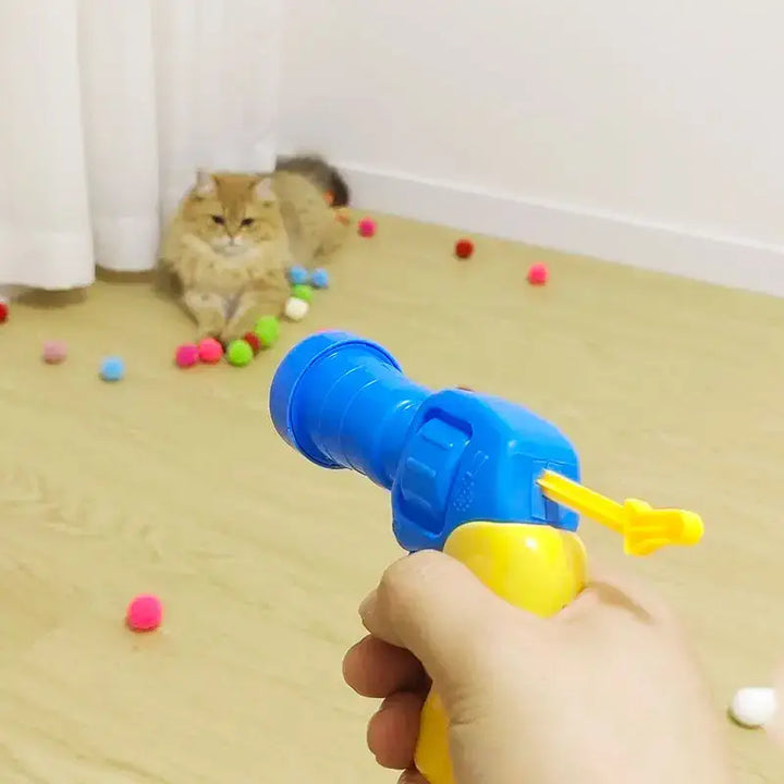 Chat jouant avec un pistolet lanceur de balles, un jouet interactif pour stimuler l'activité et l'amusement des chats.